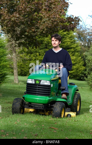 Petite balade en tracteur John Deere sur le paillage de tondeuse à gazon rugueux au début de l'automne Banque D'Images