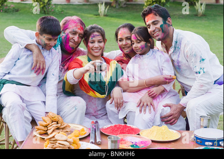 Famille de prendre une photo d'eux-mêmes avec un appareil photo sur Holi Banque D'Images