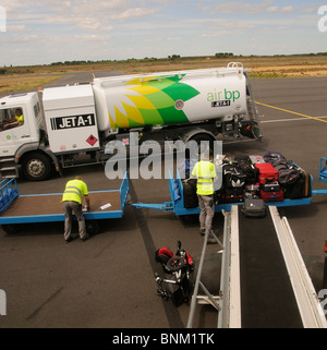 Carburant pour aéronefs truck & bagagiste chargement de sacs un chariot sur un avion à l'Aéroport International de Béziers S France Banque D'Images