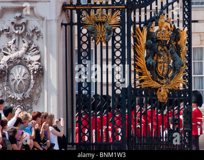 Les touristes regarder le "changement de garde" au palais de Buckingham, Londres. Banque D'Images