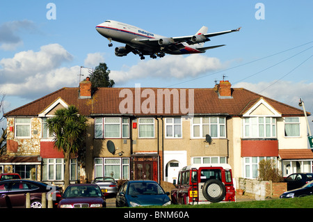 Approche de la piste d'Heathrow par Boeing 747, Malaysia Airlines, en approche à basse altitude au-dessus des maisons pour l'atterrissage à l'aéroport Heathrow de Londres, Myrtle Avenue, UK. Banque D'Images