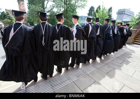Les diplômés de sexe masculin jusqu'à se faire prendre en photo après leurs diplômes à l'Université de Birmingham. Banque D'Images