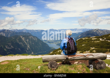 Senior woman looking at vue de lac de montagne Krippenstein Hallstattersee dans Alpes Massif du Dachstein. L'Autriche, de l'Europe. Banque D'Images