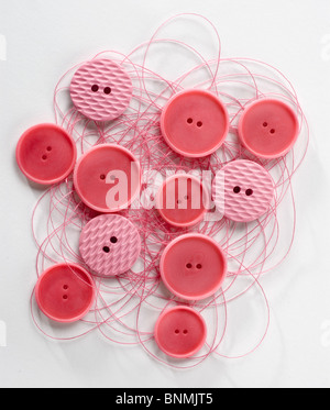 Boutons rouges sur red thread cut out Banque D'Images