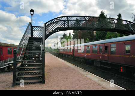 Machine à vapeur / locomotive avec les voitures rouges à la Boat of Garten railway station, Ecosse, Royaume-Uni Banque D'Images