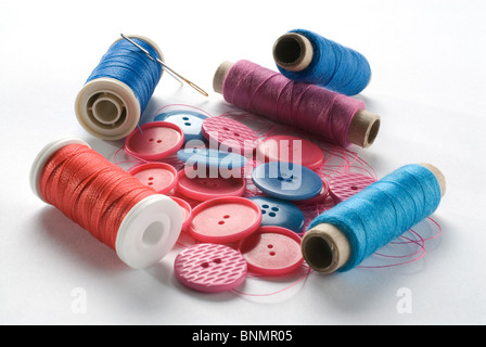 Bleu coloré et fils rouges et boutons sur fond blanc Banque D'Images