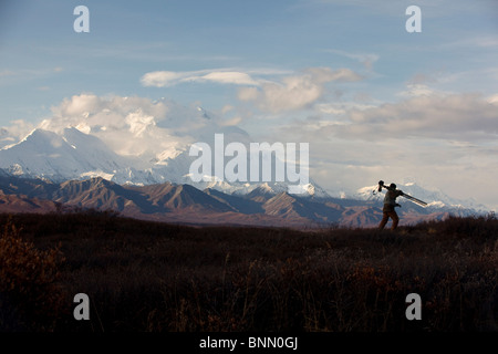 Silhouette d'un photographe avec son trépied et appareil photo et le Mont McKinley en arrière-plan, le parc national Denali, Alaska Banque D'Images