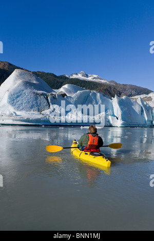 Un kayakiste paddles les eaux glacées du lac Mendenhall Glacier Mendenhall avec et Mt. Dans l'arrière-plan blanc poussette, Alaska Banque D'Images