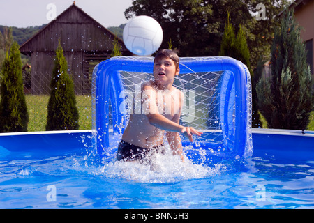 Adolescent jetant de l'eau polo ball dans la piscine. Banque D'Images