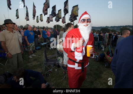 Festival de Glastonbury. Homme habillé en costume déguisement en Père Noël / Santa Claus dans une foule. Banque D'Images