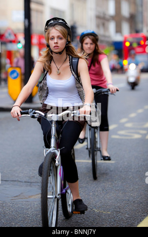 Deux jeunes femmes à vélo sur Oxford Street, London, England, UK Banque D'Images