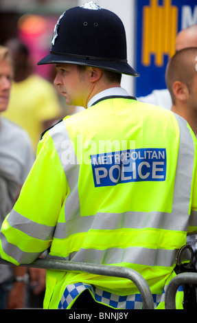 Vue arrière d'un agent de police métropolitaine portant un gilet jaune, London, England, UK Banque D'Images