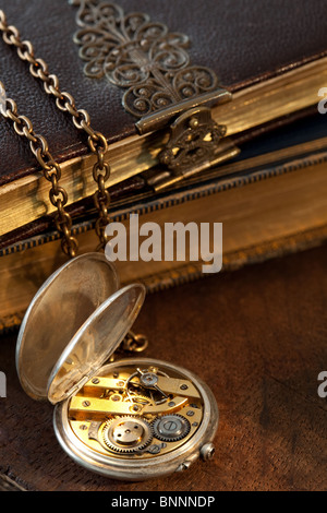 Vieux livres floue sur l'arrière-plan d'un antique pocket watch Banque D'Images