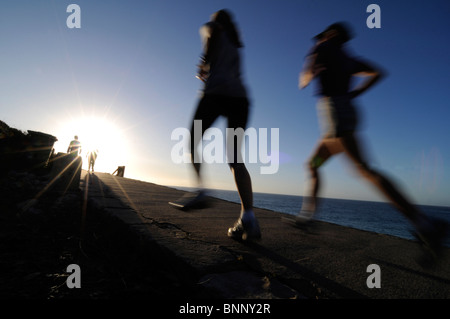 Women jogging tôt le matin sur la piste côtière près de Bondi à Sydney en Australie, banlieue Est. Banque D'Images
