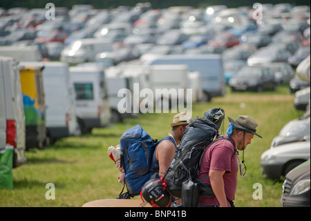 Les festivaliers à faire leur chemin à l'écart de la réalisation de matériel de camping. Festival de Glastonbury, Somerset, Angleterre, 2010 Banque D'Images