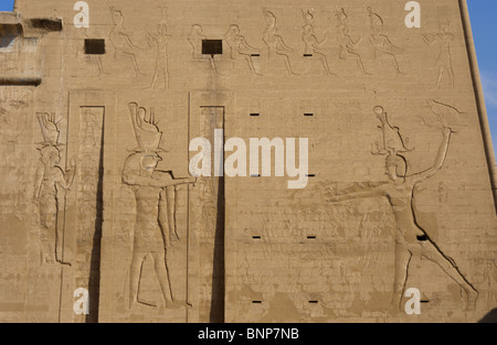 Temple d'Horus. Le pharaon Ptolémée XII Neo Dionysos sacrifier des prisonniers à l'Horus dieu et déesse Hahtor. Edfou. L'Égypte. Banque D'Images