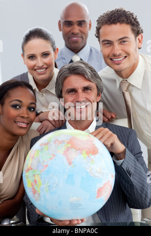 L'équipe entreprises gaies montrant un globe terrestre Banque D'Images