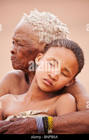 Bushman/peuple San. Jeune fille à la vieille femme embracing Banque D'Images