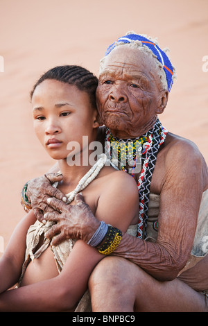 Bushman/peuple San. Jeune fille à la vieille femme embracing Banque D'Images