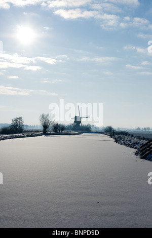 Rivière gelée et moulin à vent en Hollande pendant l'hiver Banque D'Images