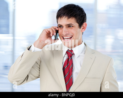 Laghing businessman talking on phone standing Banque D'Images