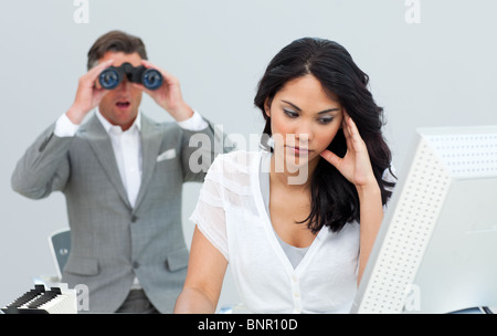 Young businesswoman getting bored et son gestionnaire binoculars Banque D'Images