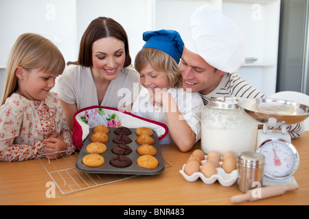 La famille joyeux présentant leurs muffins Banque D'Images