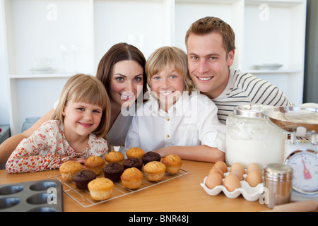 Famille heureuse de présenter leurs muffins Banque D'Images