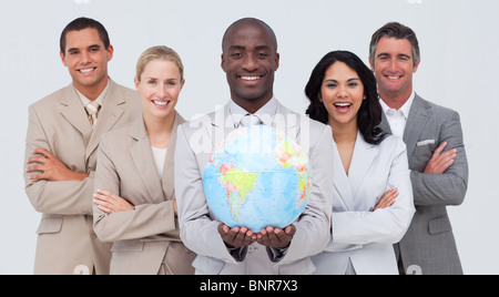 Libre businessman holding a globe terrestre avec son équipe Banque D'Images