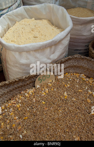 Le Maroc, Tétouan. Médina historique Bazar. Céréales assorties dans panier avec des sacs de farine. Banque D'Images