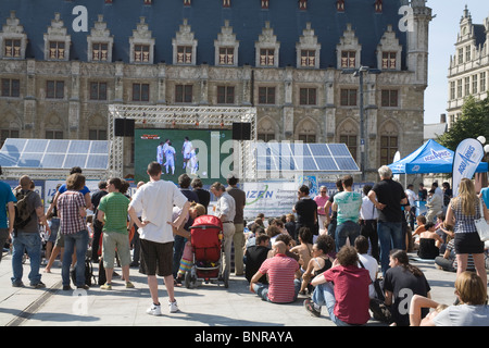 Belgique Europe EU foule regardant un match de foot sur un téléviseur alimenté par des panneaux solaires Banque D'Images