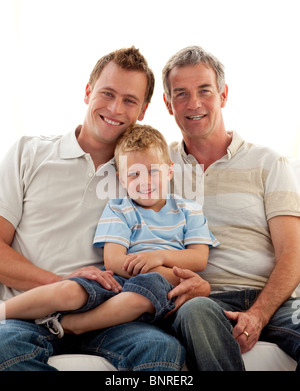 Smiling fils, père et grand-père sitting on sofa Banque D'Images