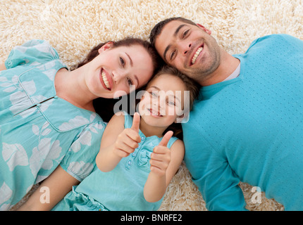 Les parents et la fille au sol avec Thumbs up Banque D'Images