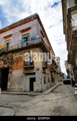 Coin avec érodé la façade de l'immeuble contre le ciel bleu dans la rue San Ignacio, La Havane, Cuba Banque D'Images