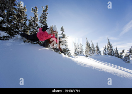 Un homme et une femme jouent dans la neige dans les montagnes. Banque D'Images