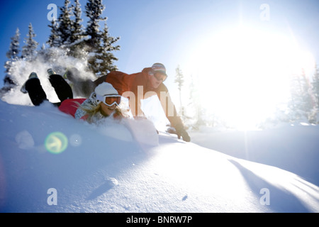 Un homme et une femme jouent dans la neige dans les montagnes. Banque D'Images