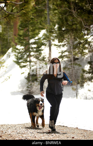 Une femme courir avec son chien à la montagne. Banque D'Images