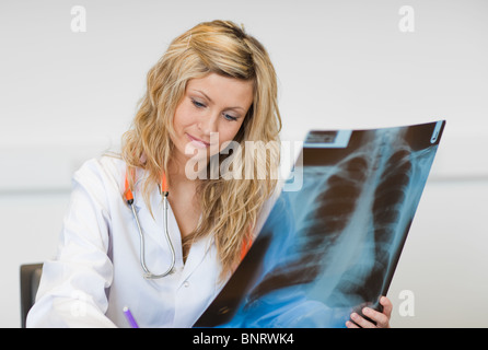 Femme tenant un chirurgien brillant X-ray report Banque D'Images