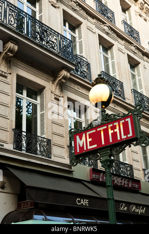 Paris Métro signe sur old style lampadaire à Paris rue par cafe et création avec des portes-fenêtres avec balcon Banque D'Images