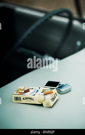 Les cigarettes Camel et paquet avec un briquet Zippo dans l'intérieur d'un véhicule Buick Lesabre 1961 Banque D'Images