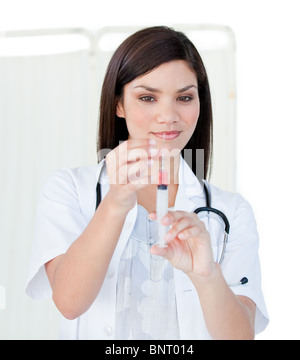 Portrait of a cute femme médecin la préparation d'une seringue dans un hôpital Banque D'Images