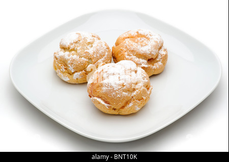 Profiteroles trois sur une plaque, isolé, fond blanc Banque D'Images