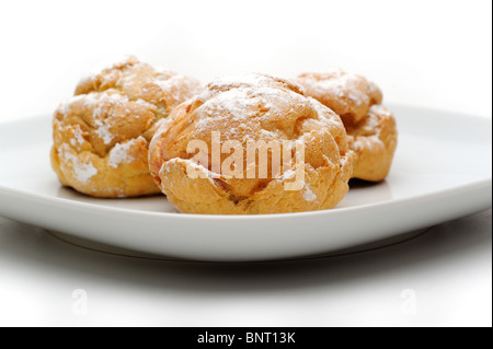 Profiteroles trois sur une plaque, isolé, fond blanc Banque D'Images