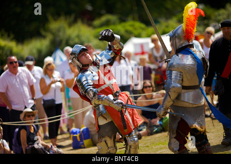 Habillé en armure authentique et à l'aide d'épées réel de reconstitution historique comme duel médiéval lors d'une fête médiévale qui a eu lieu à Arundel Banque D'Images