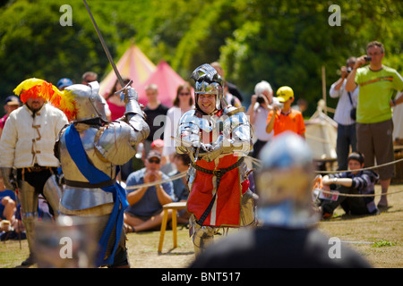 Habillé en armure authentique et à l'aide d'épées réel de reconstitution historique comme duel médiéval lors d'une fête médiévale qui a eu lieu à Arundel Banque D'Images