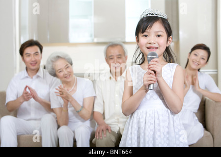 Petite fille chante devant sa famille Banque D'Images