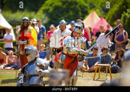 Habillé en armure authentique et à l'aide d'épées réel de reconstitution historique comme duel médiéval lors d'une fête médiévale qui a eu lieu à Arundel Banque D'Images