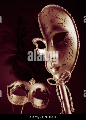 Deux beaux masques Vénitiens sur fond rouge noir Banque D'Images