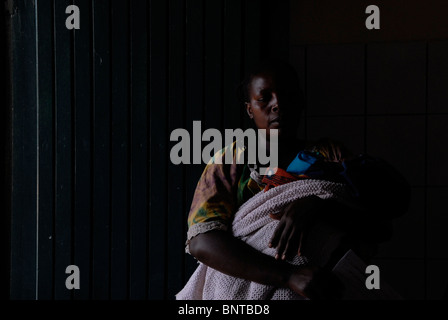 Une femme congolaise avec son bébé attendant une assistance médicale au centre médical de Kiganga. Province du Nord-Kivu, RD Congo Afrique Banque D'Images