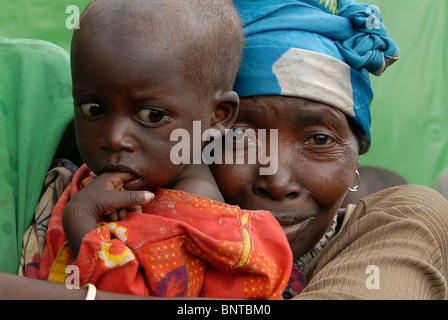 Femme congolaise déplacées avec un look tout-petits malnutris abattu dans un camp de personnes déplacées au Nord Kivu, RD Congo l'Afrique centrale Banque D'Images
